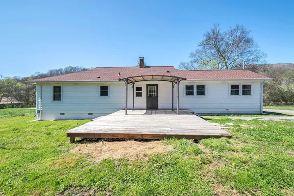 a front view of house with yard and trees in the background