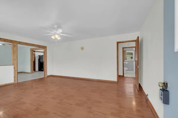 a view of an empty room with a window and wooden floor