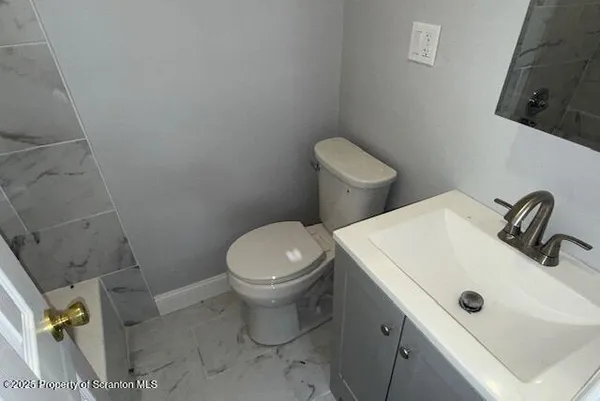 a white toilet sitting next to a bathroom sink