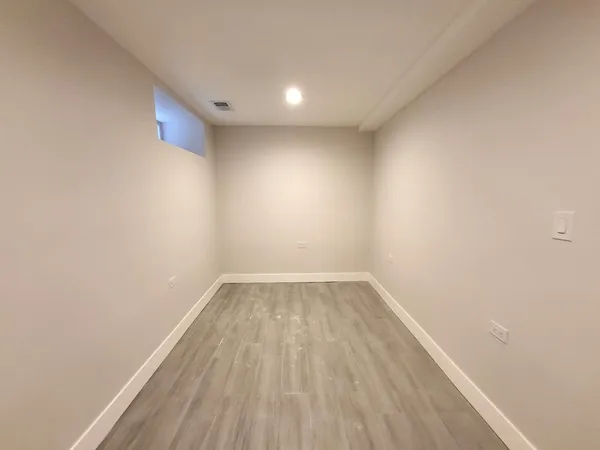 a view of empty room with wooden floor
