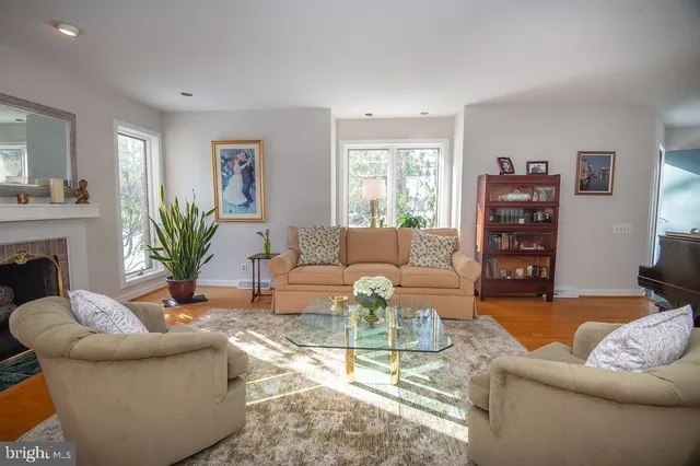 a living room with furniture a piano and a fireplace