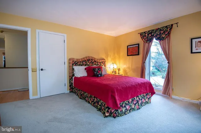 a bedroom with a large bed and wooden floor
