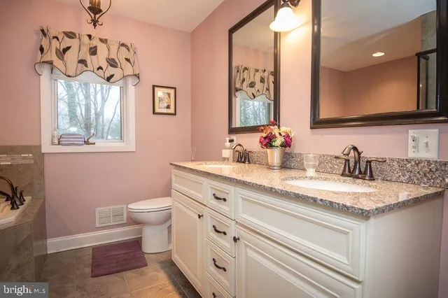 a bathroom with a granite countertop sink a mirror and a shower