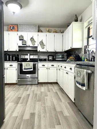 a kitchen with granite countertop a sink stainless steel appliances and cabinets