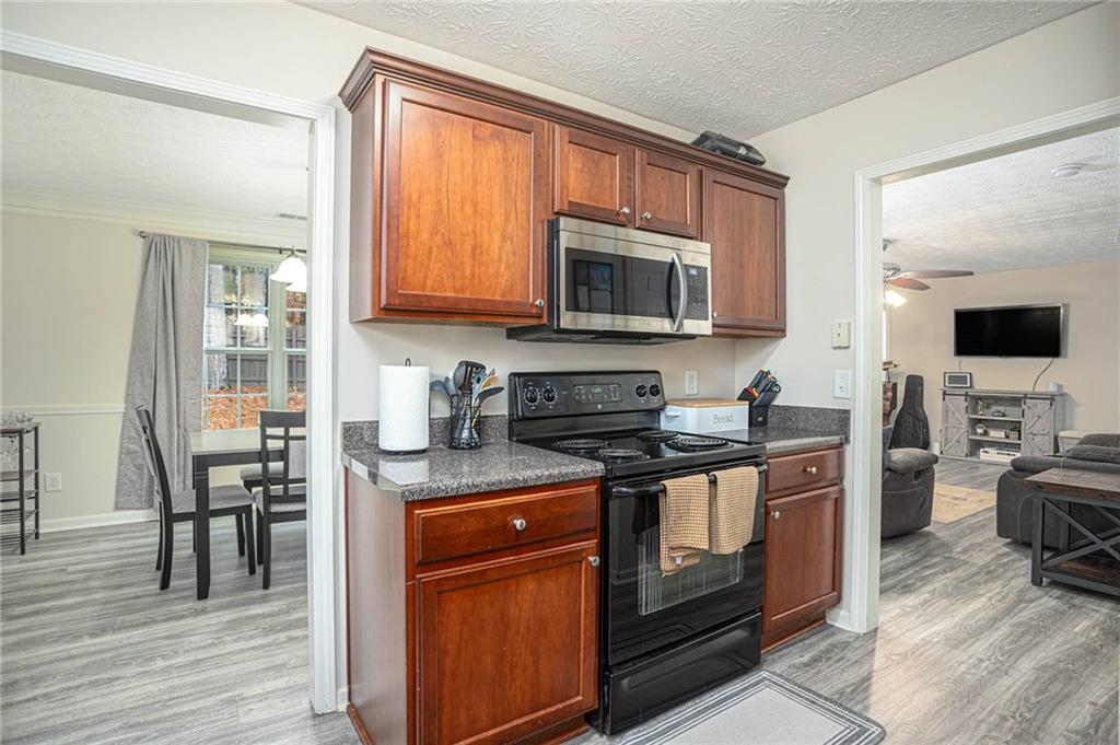 3954 Riverside Parkway Decatur, GA 30034 - Photo 18 of 38 a kitchen with stainless steel appliances granite countertop a stove top oven a sink dishwasher a dining table and chairs with wooden floor