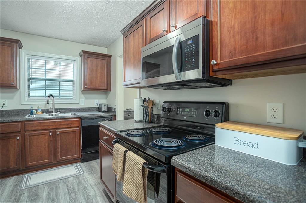 3954 Riverside Parkway Decatur, GA 30034 - Photo 19 of 38 a kitchen with stainless steel appliances granite countertop a stove a sink and a microwave