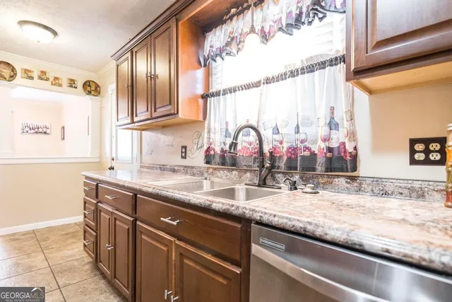 a kitchen with stainless steel appliances granite countertop a sink and dishwasher next to a window