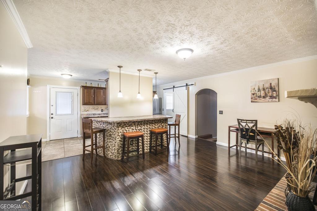 35 Commerce Street Alamo, GA 30411 - Photo 25 of 37 a dining room with furniture wooden floor a rug and a kitchen