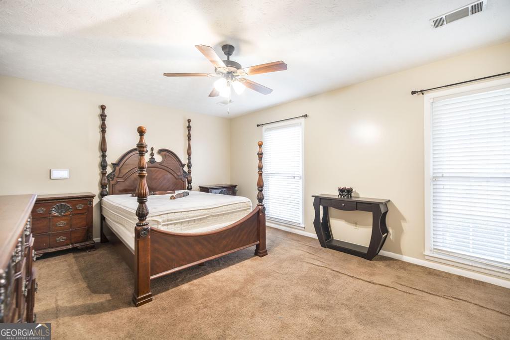 35 Commerce Street Alamo, GA 30411 - Photo 30 of 37 a bedroom with a bed and a chandelier