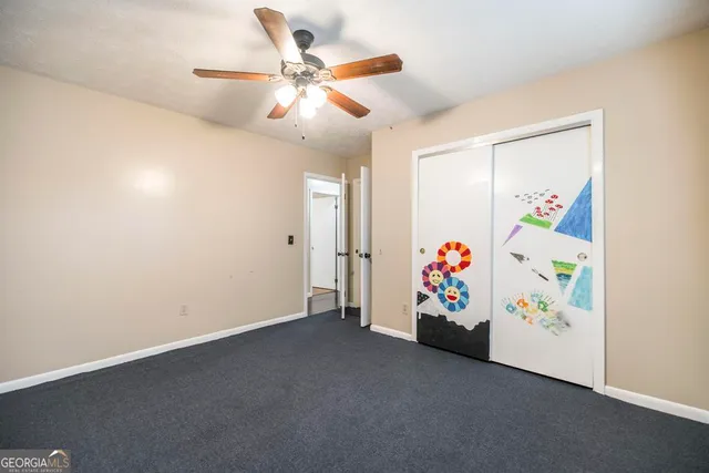 an empty room with a window and a fan