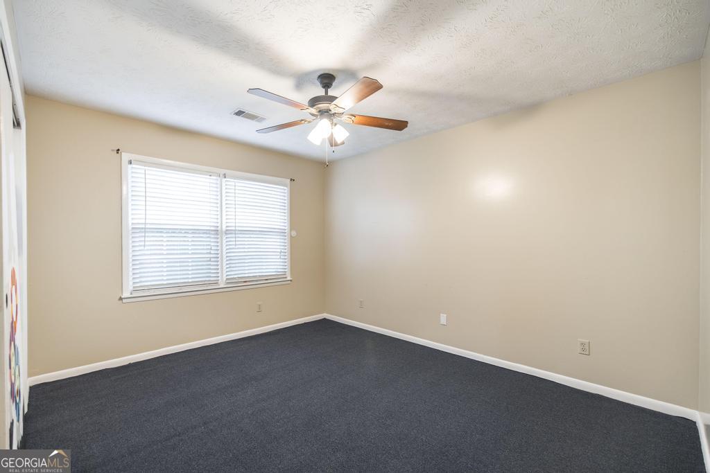 35 Commerce Street Alamo, GA 30411 - Photo 32 of 37 an empty room with a window and a fan