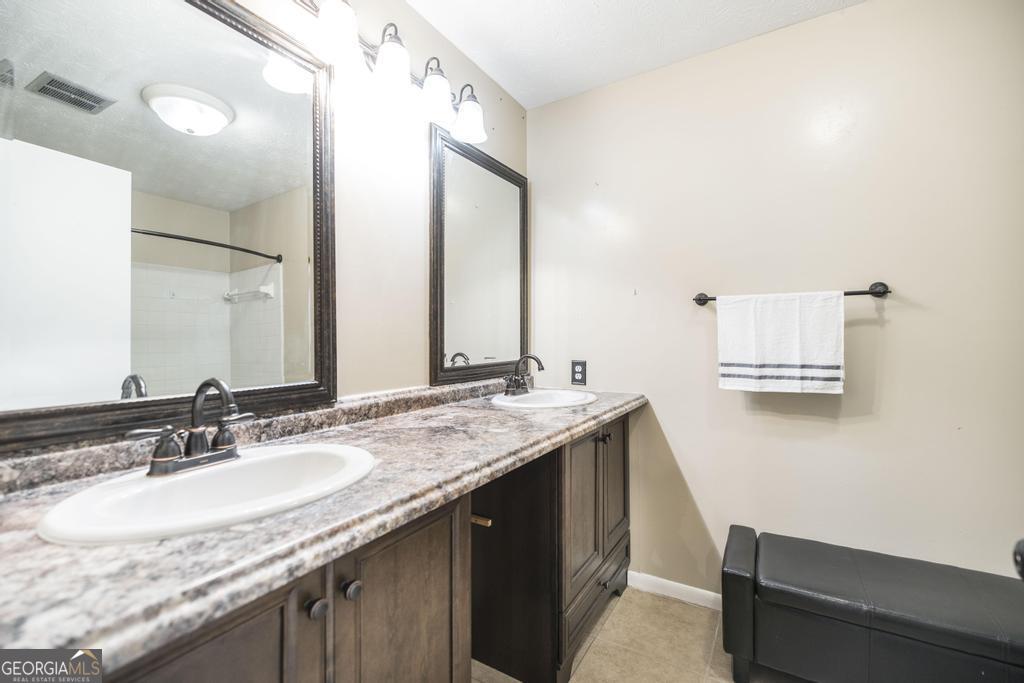 35 Commerce Street Alamo, GA 30411 - Photo 35 of 37 a bathroom with a granite countertop sink and a mirror