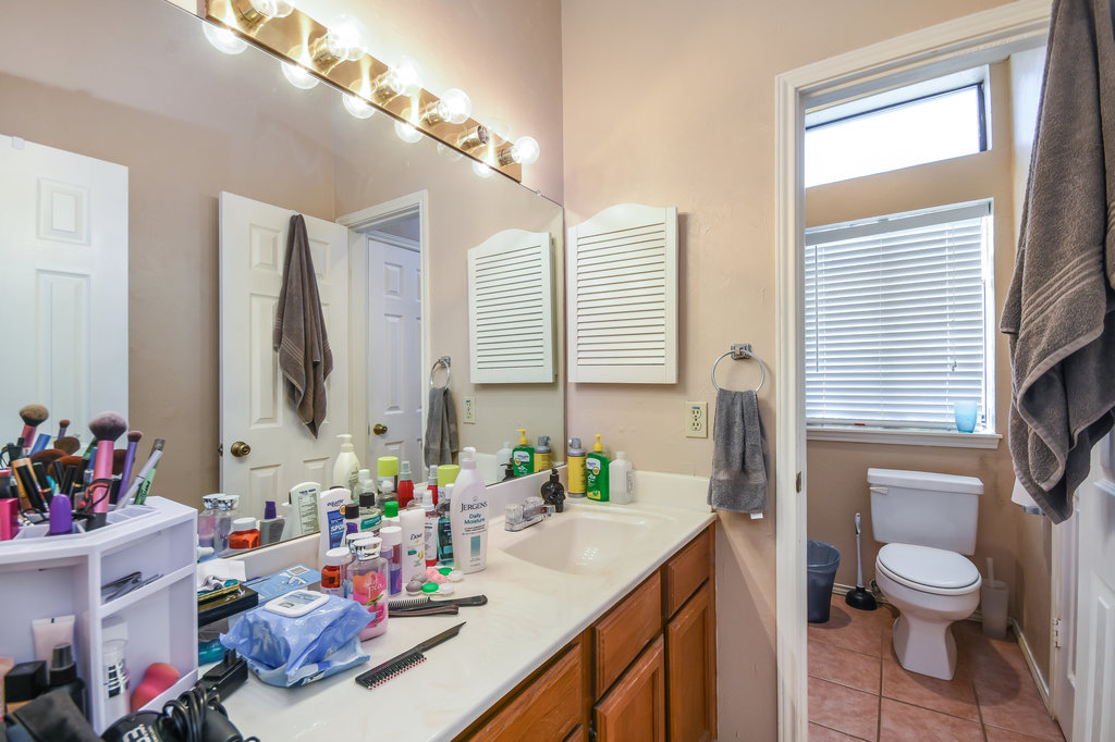 2802 Nueces Street, Unit 312 Austin, TX 78705 - Photo 14 of 22 a bathroom with a sink vanity mirror and toilet