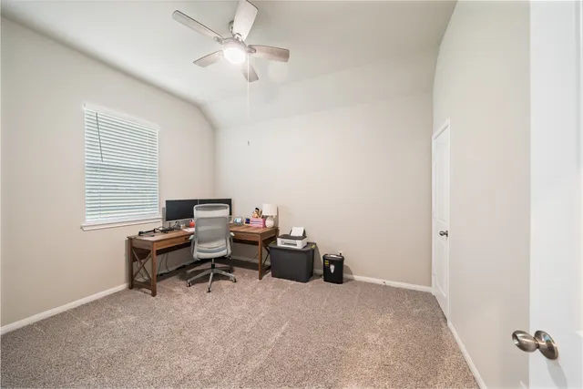 a view of a workspace with furniture and a window