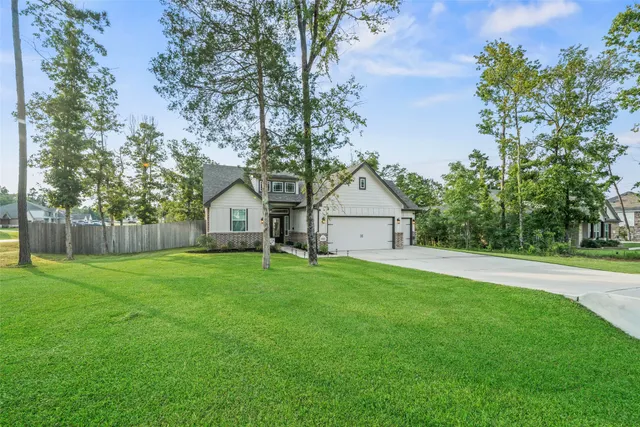 a view of a big yard with large tree and wooden fence