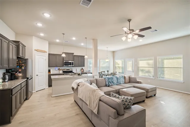 a living room with furniture flat screen tv and large window
