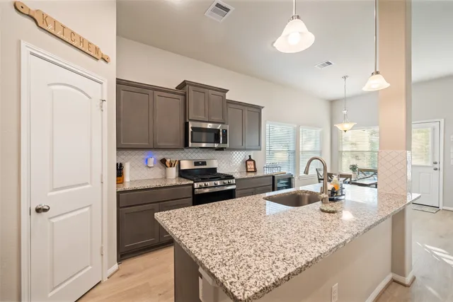 a kitchen with a sink a stove and cabinets