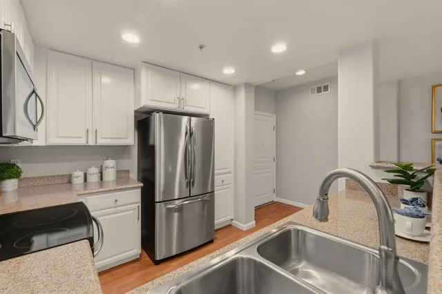 a kitchen with stainless steel appliances a refrigerator sink and cabinets