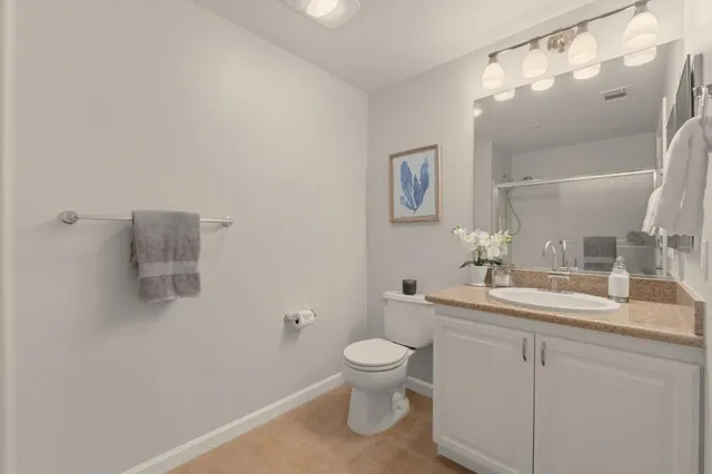 a bathroom with a toilet a sink and mirror