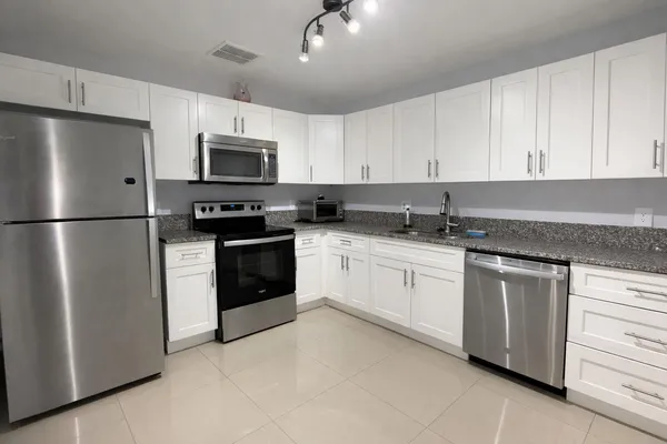 a kitchen with cabinets stainless steel appliances and a counter space