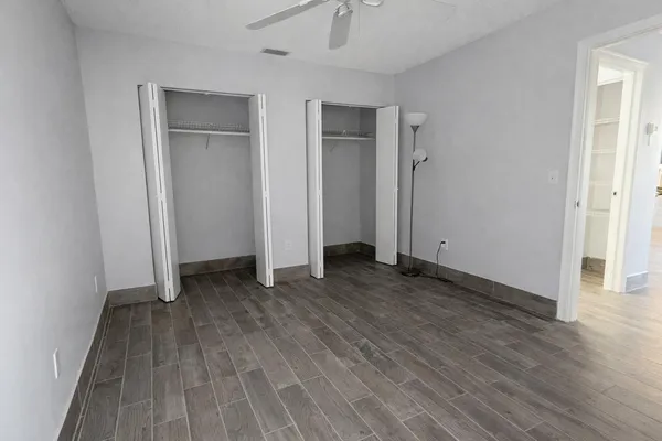 an empty room with wooden floor and entrance