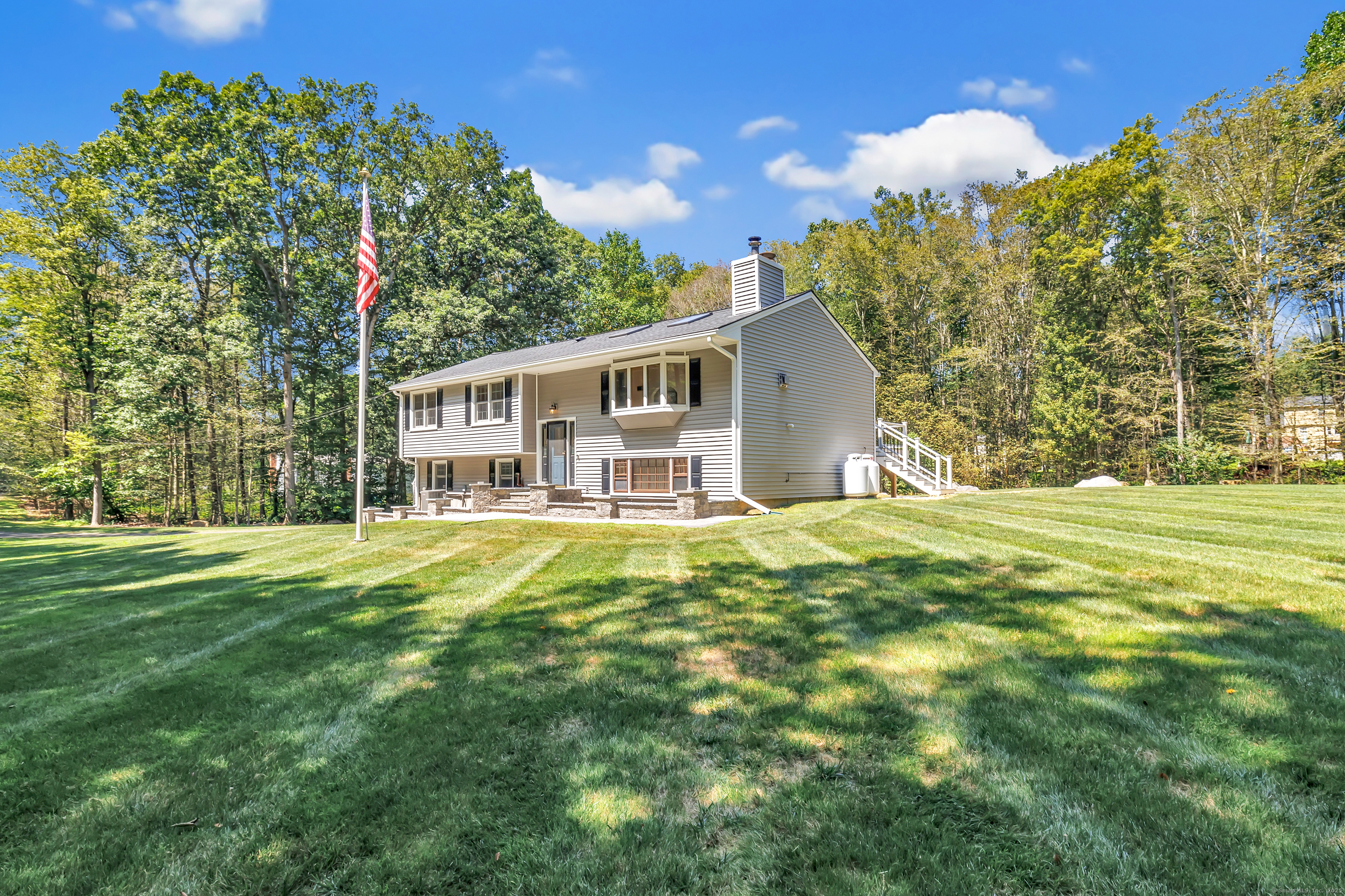 a view of a house with a big yard and large trees