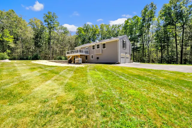 a view of a house with pool and a yard