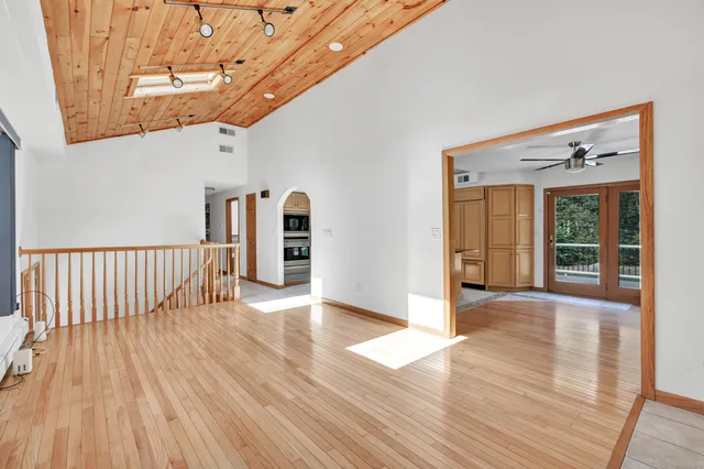 a view of a hallway with wooden floor and fence