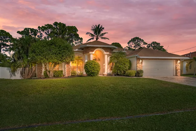 a front view of a house with a garden