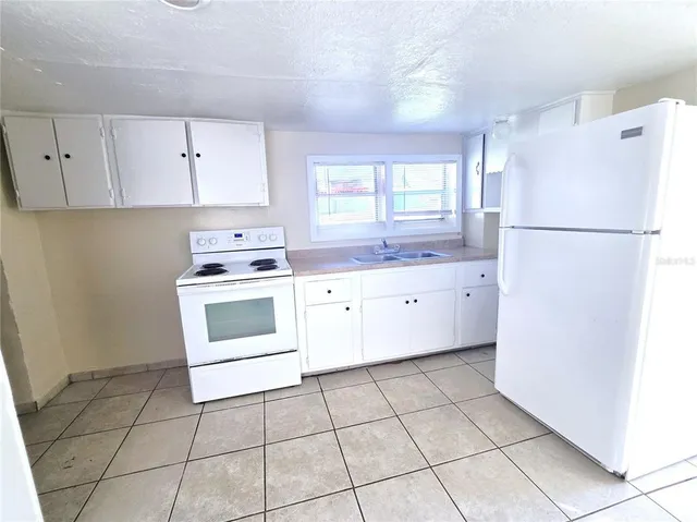 a kitchen with a stove a sink and a refrigerator
