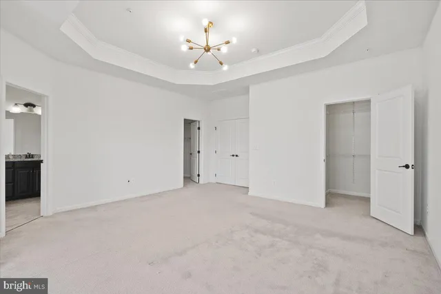 a view of an empty room with a chandelier fan