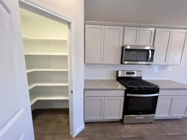 a kitchen with granite countertop a stove and a sink