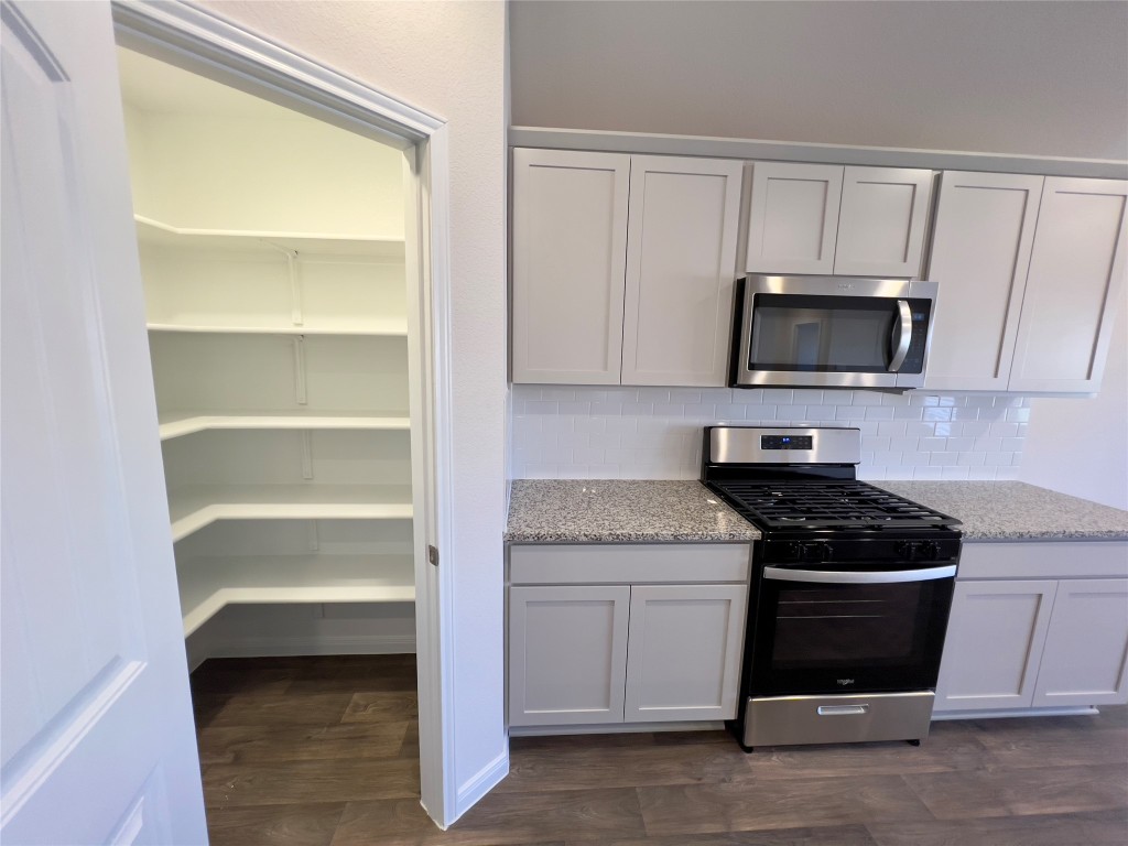 314 Addison Place Lockhart, TX 78644 - Photo 6 of 33 a kitchen with white cabinets and a stove top oven
