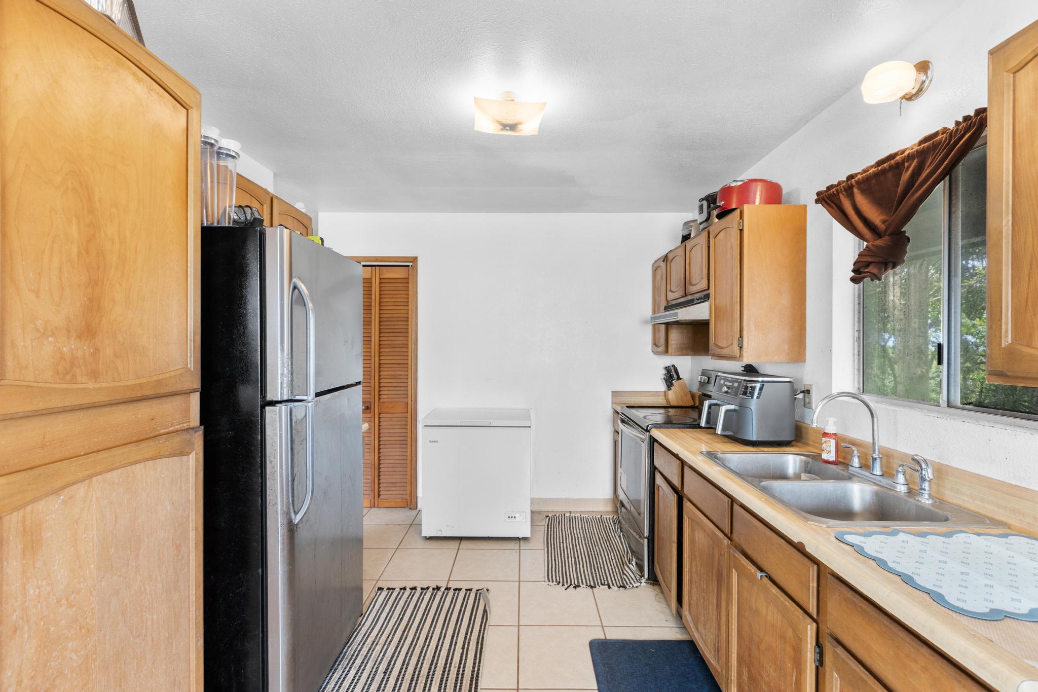 54-382 Union Mill Road Kapaau, HI 96755 - Photo 15 of 28 a kitchen with stainless steel appliances granite countertop a refrigerator and a sink