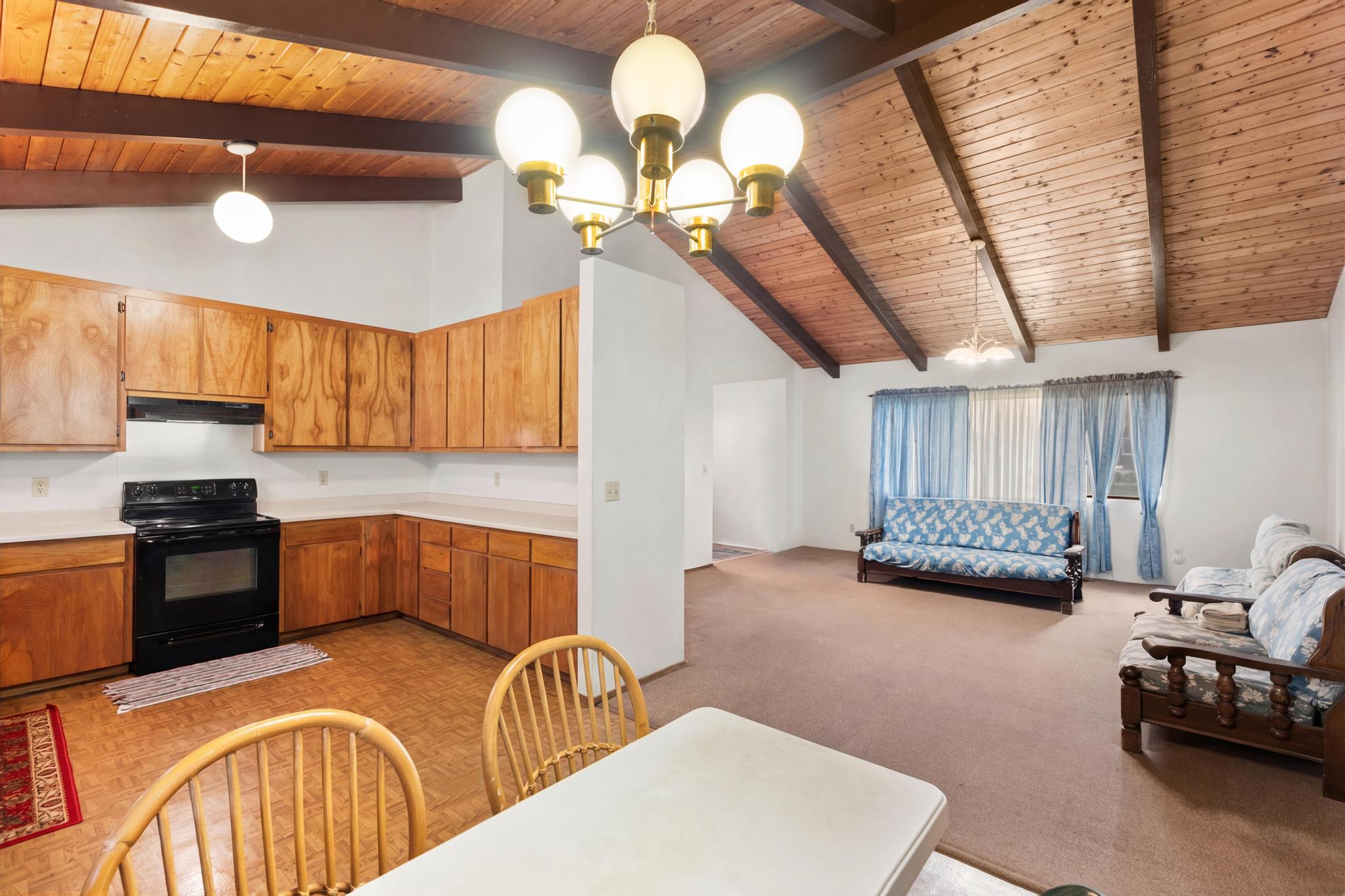 54-382 Union Mill Road Kapaau, HI 96755 - Photo 4 of 28 a kitchen with stainless steel appliances granite countertop a sink a stove a oven a dining table and chairs with wooden floor