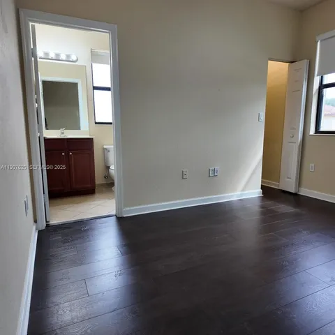 an empty room with wooden floor and mirror
