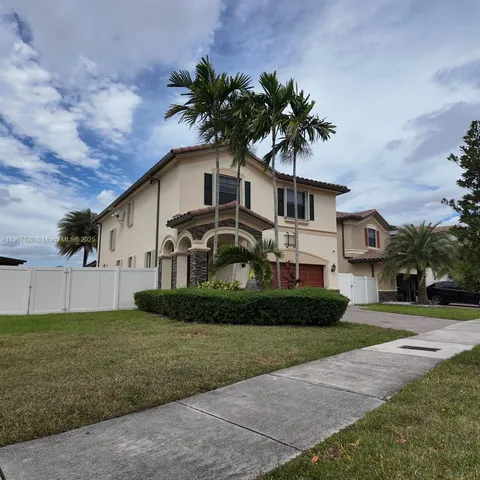 a front view of a house with a garden and trees