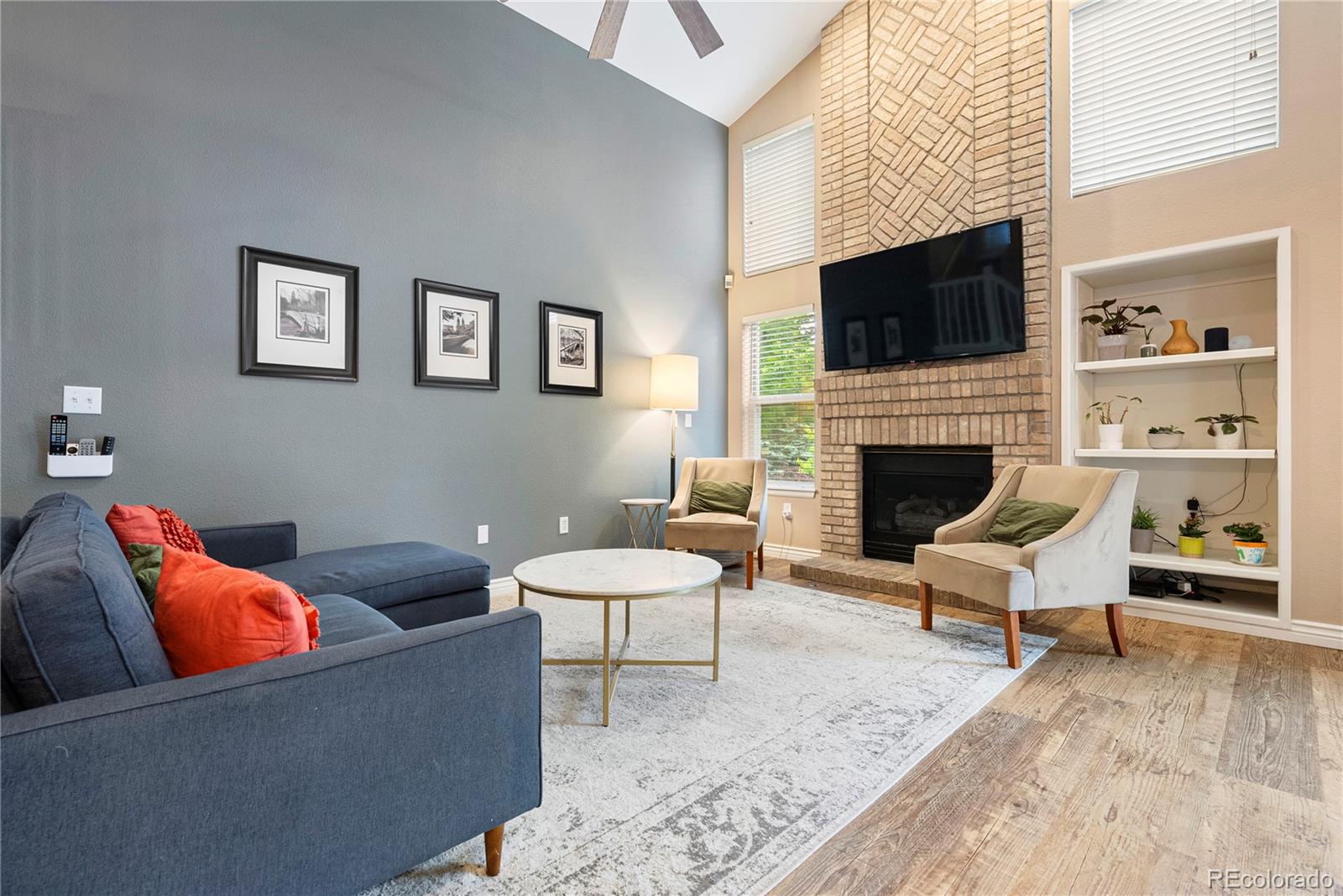 9756 Quay Loop Broomfield, CO 80021 - Photo 9 of 32 a living room with furniture a flat screen tv and a fireplace