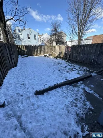 a view of a yard with wooden fence