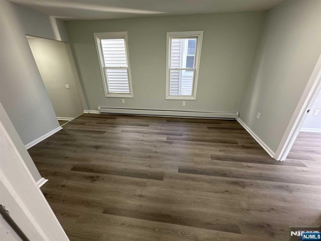 108 Madison Street Paterson, NJ 07501 - Photo 3 of 15 a view of an empty room with wooden floor and window