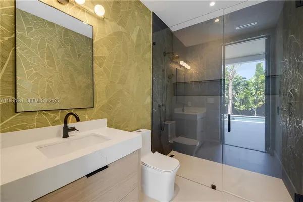 a bathroom with a sink a toilet and shower