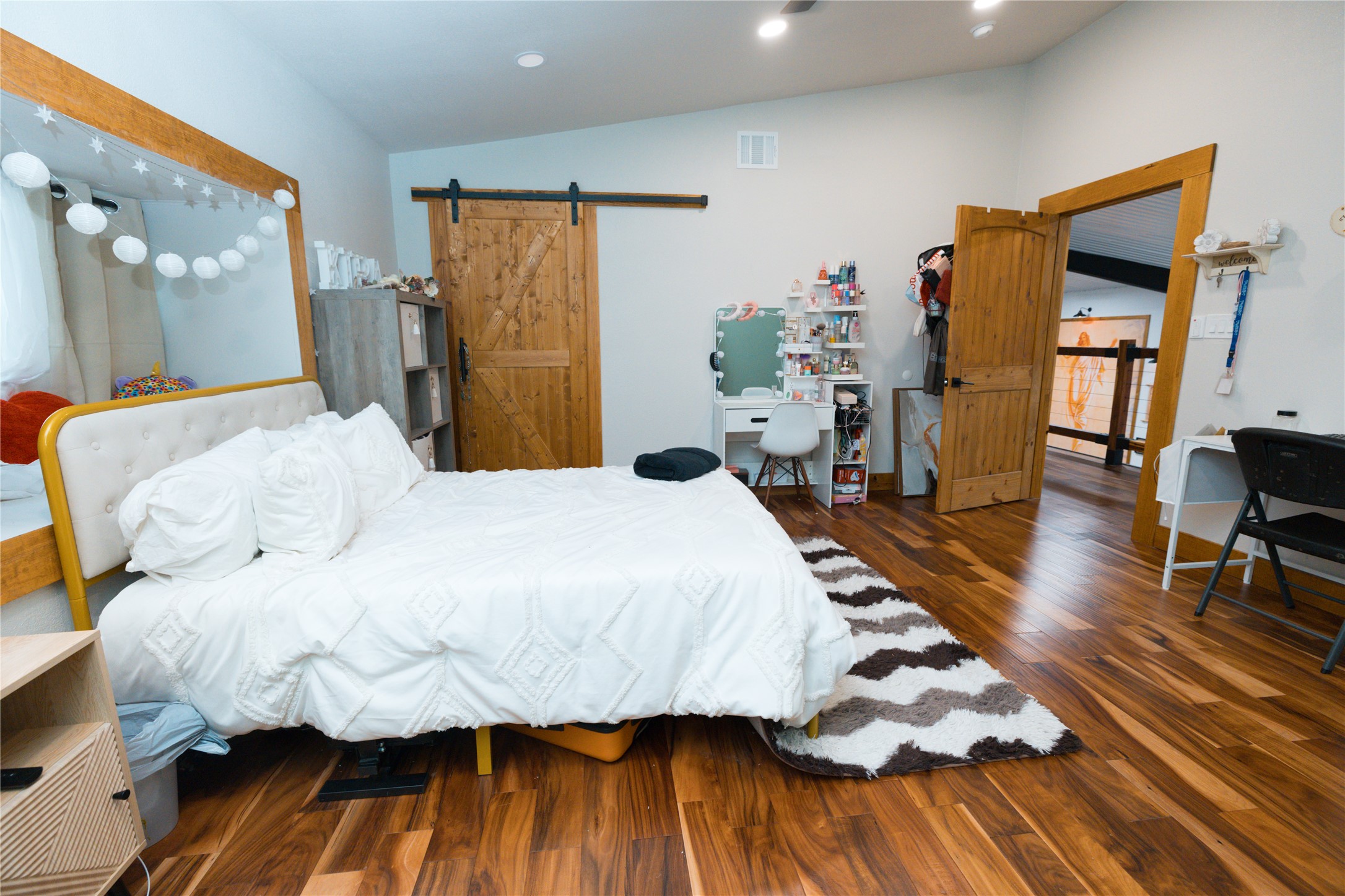 143 County Road Paige, TX 78659 - Photo 11 of 36 Bedroom 3 featuring a barn door, wood finished floors, recessed lighting, and lofted ceiling