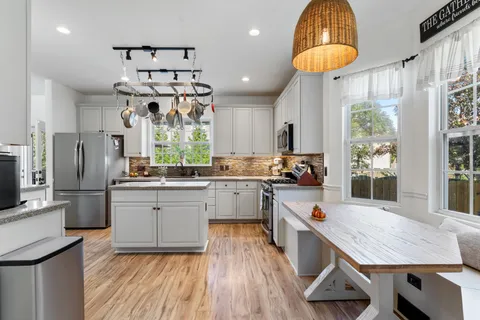 a kitchen with stainless steel appliances granite countertop a refrigerator a stove and a sink