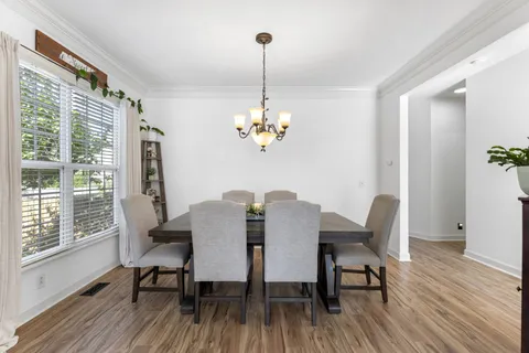 a view of a hallway with wooden floor and a bathroom