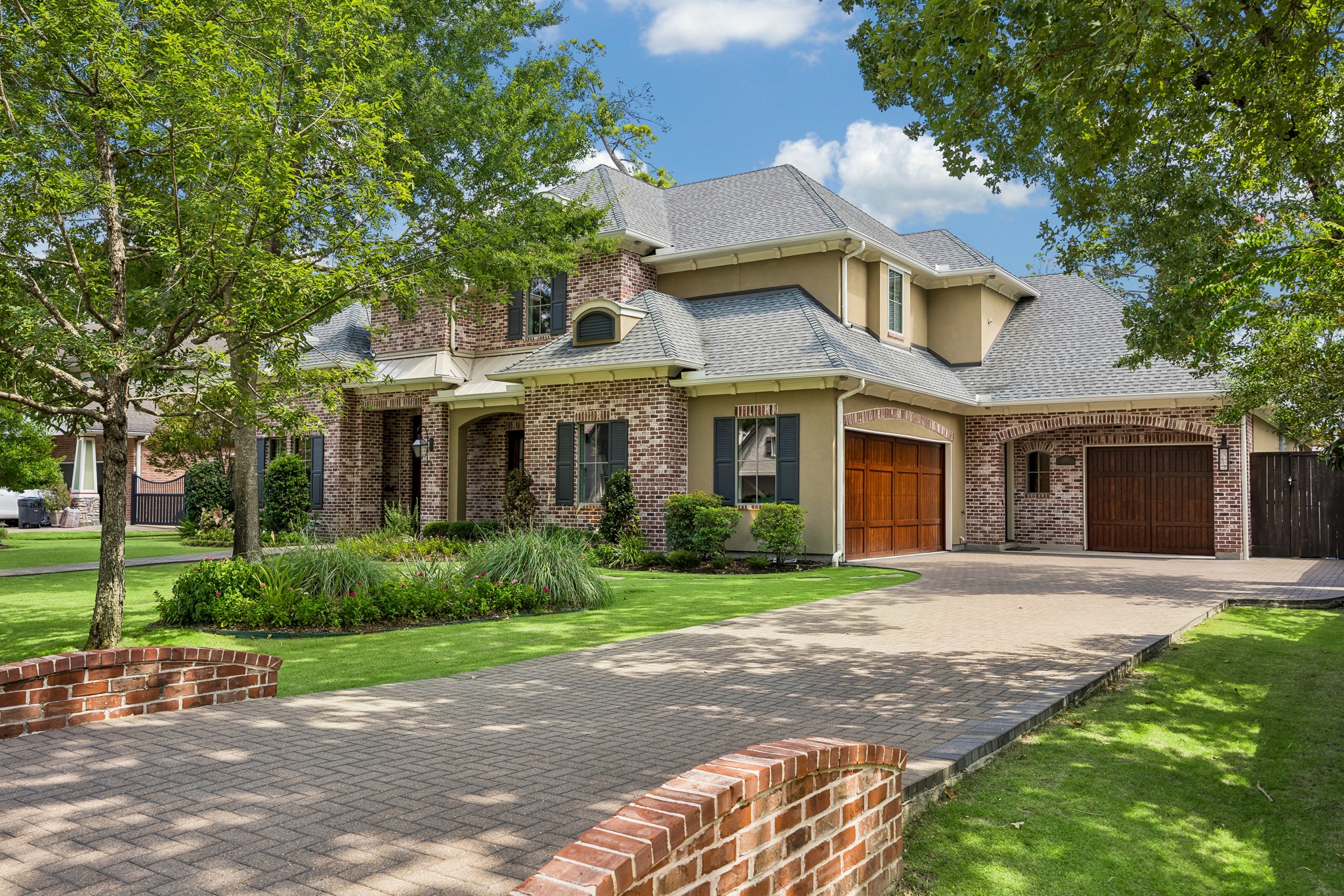 13127 Highwood Road Houston, TX 77079 - Photo 2 of 33 An impressive paver driveway welcomes you home, leading to an oversized three-car garage with an expansive motor court. Beautiful wood carriage-style garage doors enhance the home's timeless curb appeal, while a convenient side entrance provides direct access to the spacious mud room—designed for everyday functionality without compromising style.