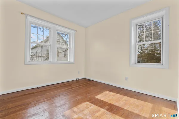 wooden floor in an empty room with a window