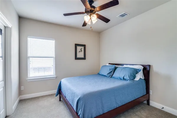 a bedroom with a large bed and two window