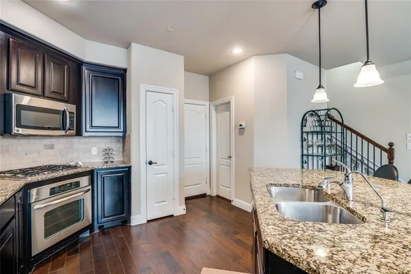 a kitchen with granite countertop wooden cabinets a stove and a stainless steel appliances