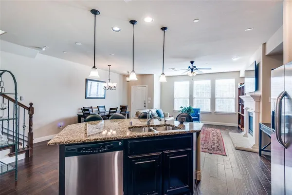 a kitchen with granite countertop a sink a counter space appliances and cabinets