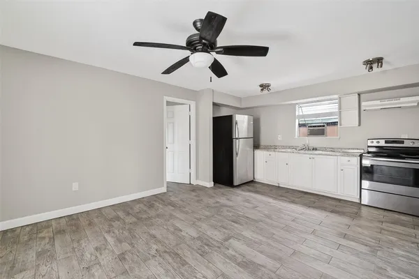 a view of empty room with wooden floor and ceiling fan